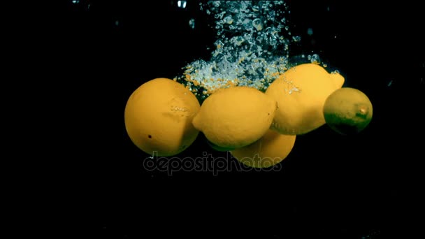 Citrusvruchten in water op een zwarte achtergrond — Stockvideo