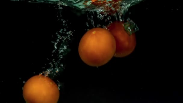 Tomates em câmera lenta flutuando na água — Vídeo de Stock