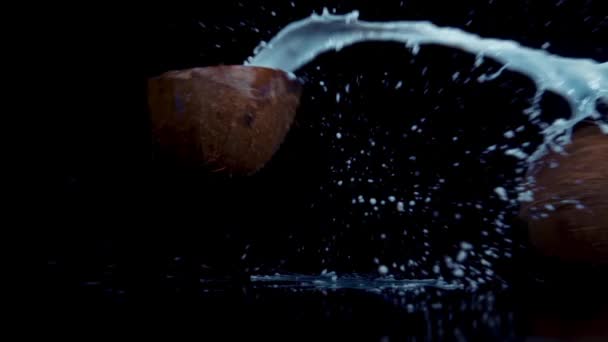 Coconut broken in slow motion on black background — Stock Video