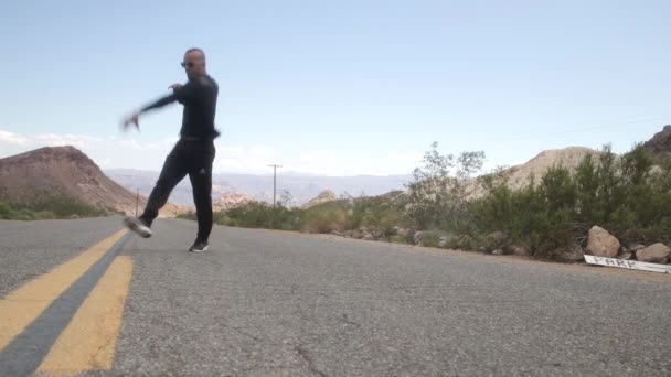 Парень танцует брейк-данс на дороге — стоковое видео