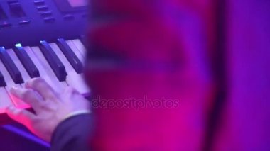 Bir adam Close-Up synthesizer anahtar taşı üstünde çalış.
