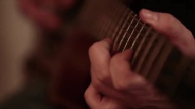 Gitar çalan bir adamın yakın çekimi.