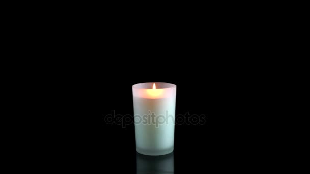 Белая свеча зажжена на черном фоне — стоковое видео