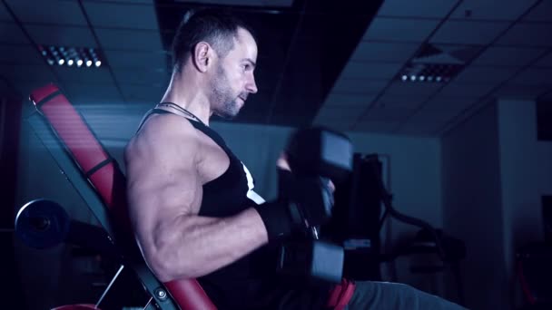 Brutal hombre sacude sus bíceps en el gimnasio — Vídeos de Stock
