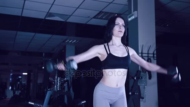 Спортивная девушка делает упражнения с гантелями — стоковое видео
