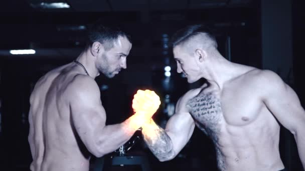 Two athletic fighters are fighting on his hands that light up with fire — Stock Video