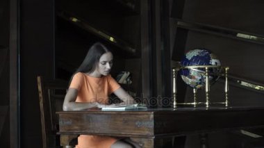 Güzel kız kütüphanede kitap okuma