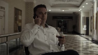 Sevimli bir adam bir kadeh kırmızı şarap bir restoranda içer.
