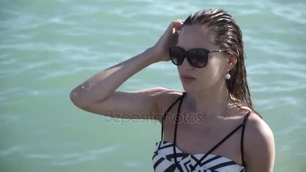 Hermosa chica sexy con el pelo mojado y gafas en el mar — Vídeo de stock