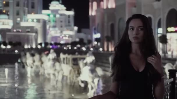 Hermosa chica en el fondo de una ciudad nocturna — Vídeos de Stock