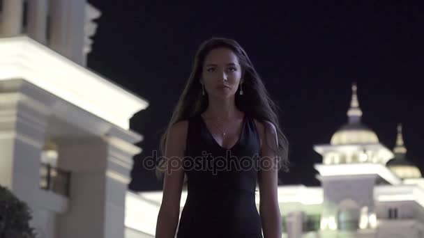 Hermosa chica en el fondo de una ciudad nocturna en cámara lenta — Vídeos de Stock