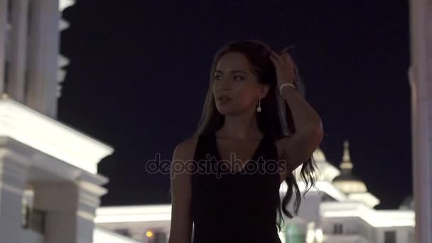 Hermosa chica en el fondo de una ciudad nocturna en cámara lenta — Vídeo de stock