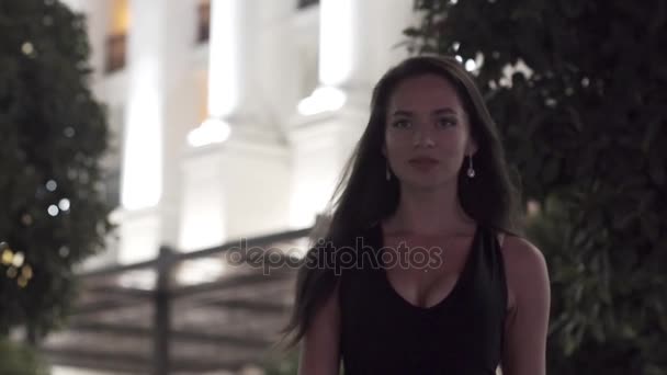 Красивая девушка на фоне ночного города в замедленной съемке — стоковое видео