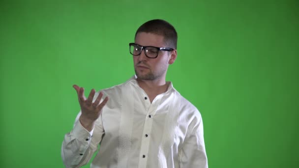 Un uomo strutturato con setole e occhiali controlla le mani con un ologramma su sfondo verde — Video Stock