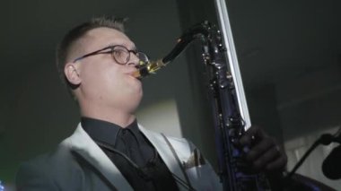 Beyaz ceketli adamı saksofoncu