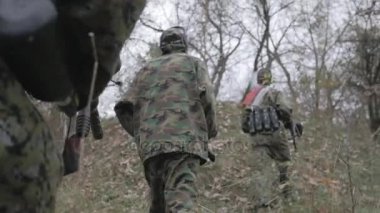 Ağır çekim ormanda yürürken Paintball oyuncu