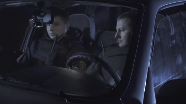 Zwei Polizisten im Auto sitzen und das Radio zu beantworten — Stockvideo