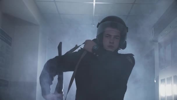 Ein Polizist in einer Abteilung im Rauch und mit einer Waffe — Stockvideo