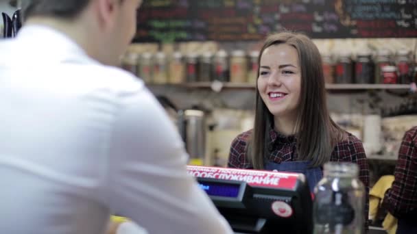 Aranyos lány eladó veszi fel a rendelést kávézóban a pénztárnál — Stock videók