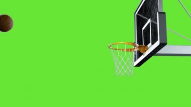 Basketbol, yeşil arka planda yavaş çekimde potaya çarptı.