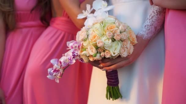 Novia con ramo de orquídeas y rosas en la mano, rodeada de damas de honor . — Vídeos de Stock