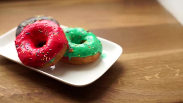 Donuts coloridos en el plato . — Vídeo de stock