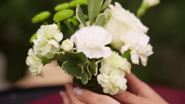 직장에서 플로리스트: 백색 로즈의 패션 현대 꽃다발을 만드는 여자. 클로즈업. — 비디오