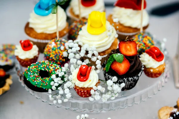 Candy bar cupcakes decorated in cowboy style. Laid out on a glass dish.