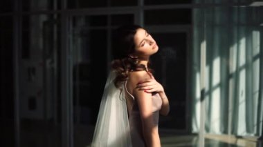 Model gelin pencereden yayılan güneş ışınlarının içinde tadını çıkarma.