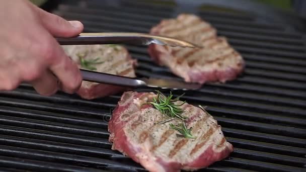 Closeup slunné venkovní šéfkuchař promění maso na grilu — Stock video