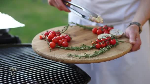 Cook vezme grilovaný česnek z grilu. — Stock video