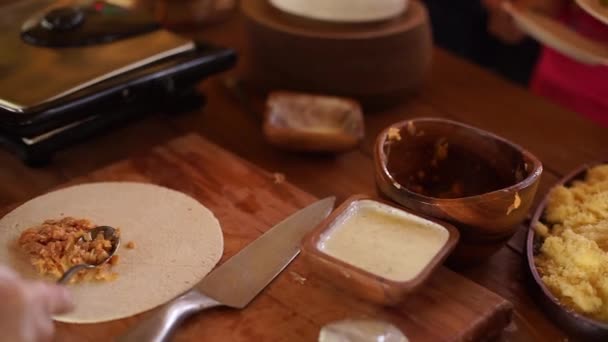 Mains de cuisinier préparant une enveloppe de fajita avec salade de bœuf et de légumes . — Video