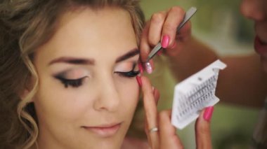 Gelin ile sahte kirpik yapıştırılmış olan. Kadın ile sağlıklı genç yüz cilt için profesyonel makyaj.