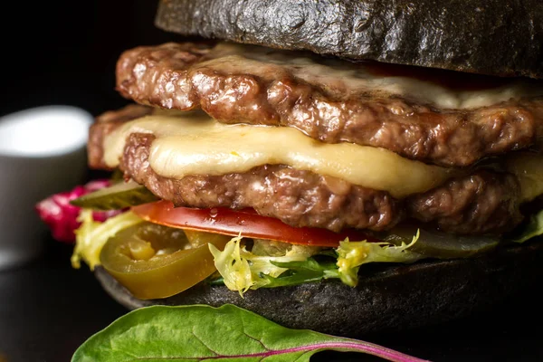 Siyah Çift Kişilik hamburger jalapeno biber ile sığır eti yapılır. Büyük yakın çekim.