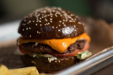 Sığır eti, peynir ve sebze yapılmış siyah Çift Kişilik hamburger.