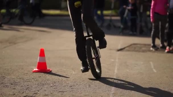 Portrait en plein air de jeune fille chevauchant un monocycle une roue vélo sur fond naturel . — Video