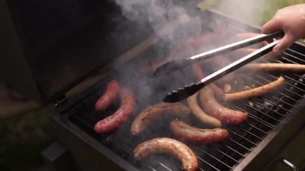 Cooks grilled sausages. — Stock Video