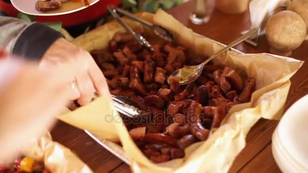 La gente pone salchichas fritas en platos . — Vídeo de stock