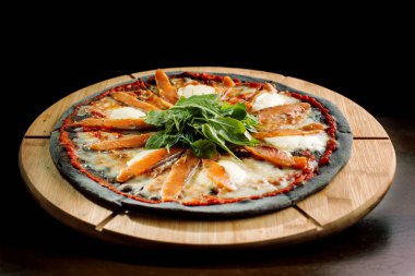 Pizza Mozzarella, somon dilim ve sebze ile.