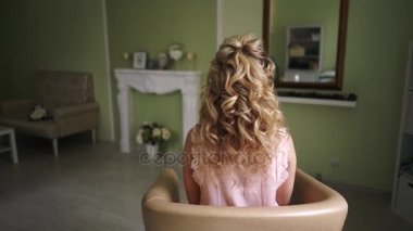 Kız güzel bir saç modeli ile kamera arkası oturur.