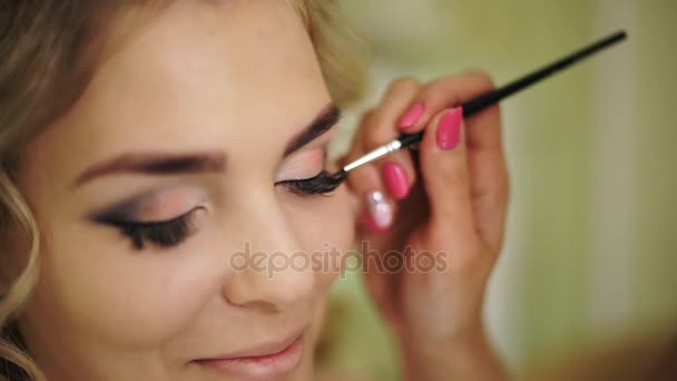 Gewichtloosheid is beschilderd met een penseel van wimpers. Professionele make-up voor vrouw met gezonde jonge gezicht huid. — Stockvideo