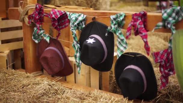 Cowboyhüte und Schals hängen am Zaun. — Stockvideo