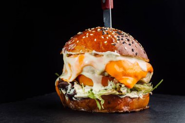Marul, peynir, soğan ve domates ile lezzetli taze ev yapımı hamburger close-up. Marul yaprakları.