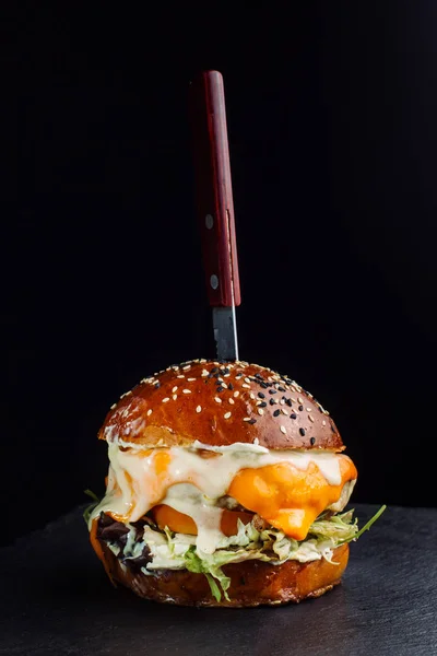 Primer plano de deliciosa hamburguesa casera fresca con lechuga, queso, cebolla y tomate. Hojas de lechuga . — Foto de Stock