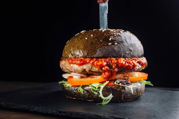 Primer plano de deliciosa hamburguesa casera fresca con lechuga, cebolla y tomate. Una gran cantidad de salsa de tomate . — Foto de Stock