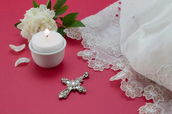 Red baptism background with white lace dress, candle and christian cross — ストック写真
