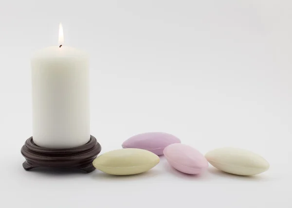 Jabones de guijarros franceses y velas encendidas aisladas en blanco —  Fotos de Stock