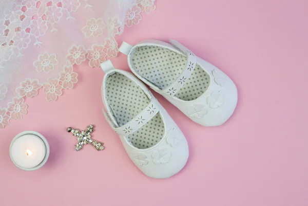 Pair of white baby booties on pink background with lace christen — ストック写真