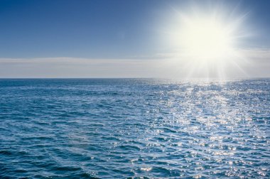 Blue sea with sunlight reflected on it clipart