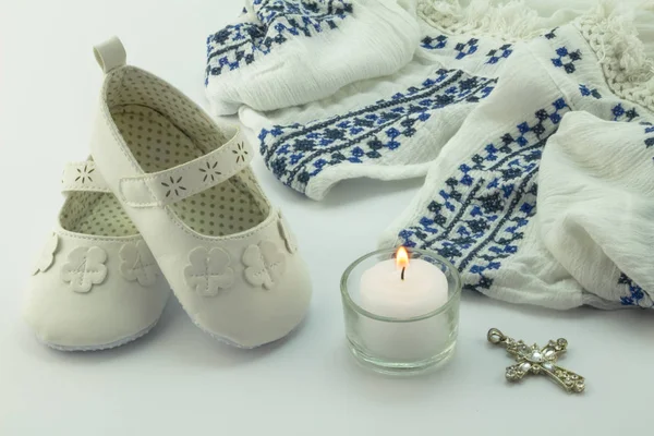 Keresztség ruha, kötött kiscipő, kereszt és gyertya fehér háttér — Stock Fotó